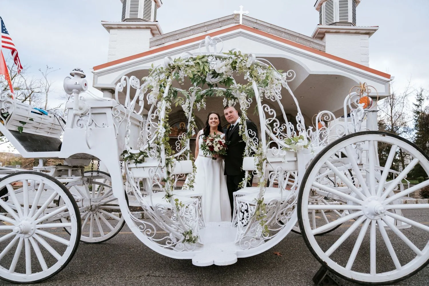 Newlyweds inside a white Cinderella carriage outside a church — Maximus Visions wedding photography, New Jersey & New York City