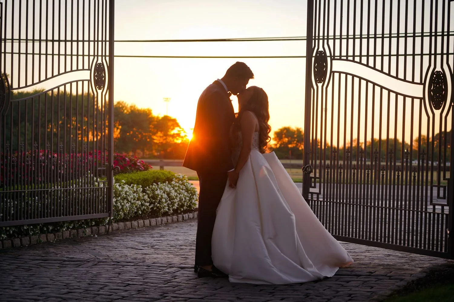 Couple silhouetted at sunset gates — Maximus Visions FAA-licensed drone and aerial photography, New Jersey & New York City