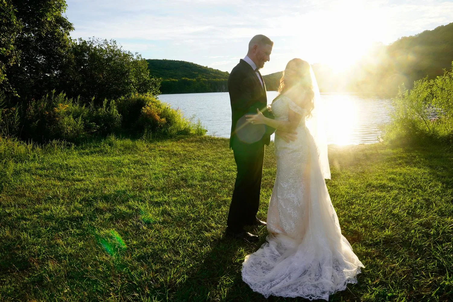 Bride and groom by a lake in golden-hour sunlight — Maximus Visions wedding, engagement, and family photography portfolio, New Jersey and New York City