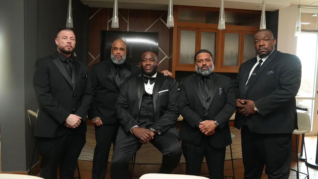 Tre and his groomsmen in all-black tuxedos, formal portrait in the hotel lounge — Maximus Visions, New Jersey