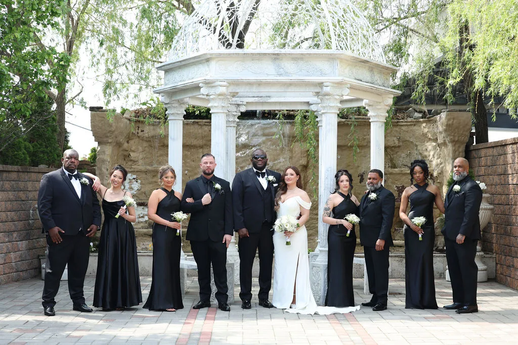 The full bridal party in black and white flanks Becky and Tre beneath the white gazebo — grand formal portrait, New Jersey wedding