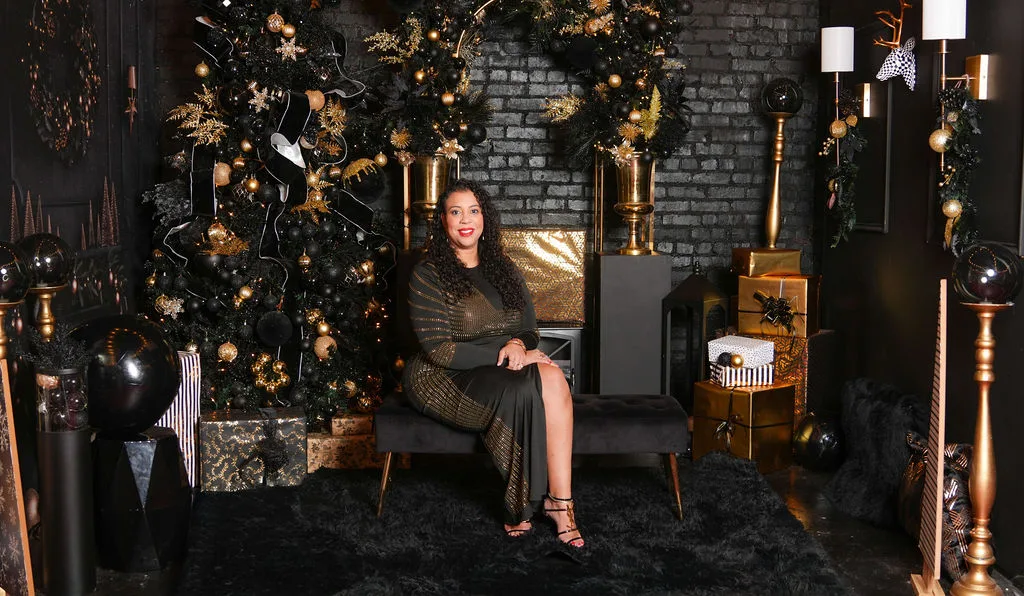 Mom seated in her black-and-gold gown beside the tree, candles lit — the closing frame of the black-and-gold set by Maximus Visions, New Jersey