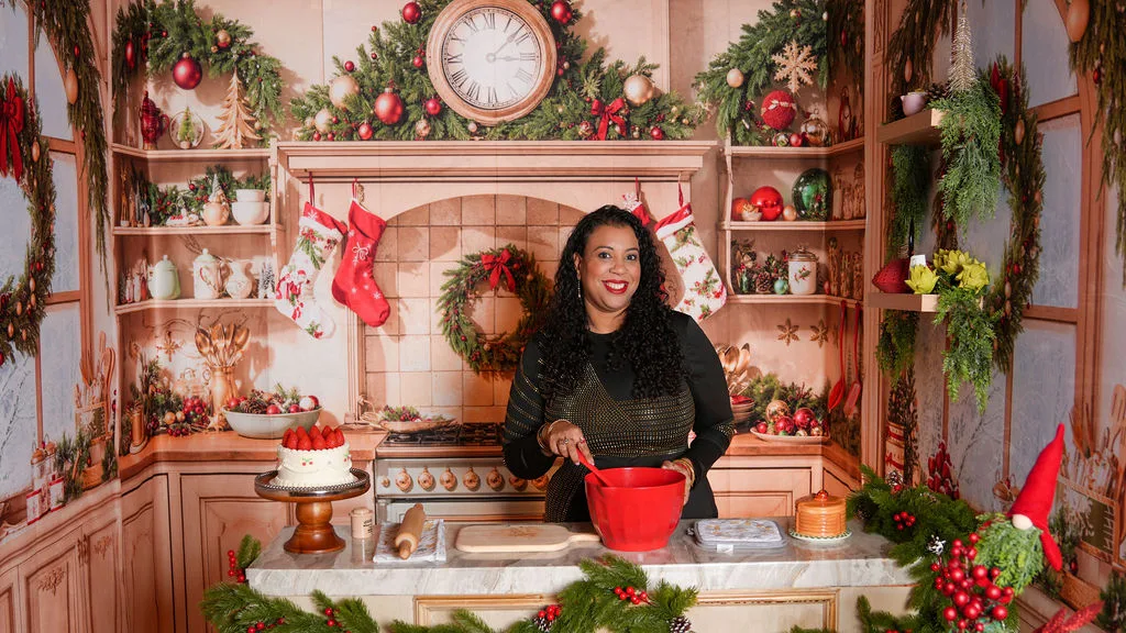 Mom in the Christmas kitchen set, red mixing bowl out and garland on the mantel — holiday session by Maximus Visions, New Jersey