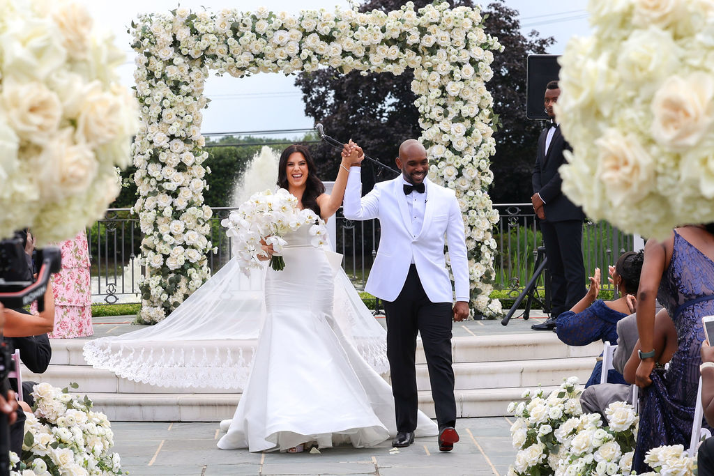 Wide recessional photo of Orin and Estefania beneath white rose chuppah, guests applauding at Park Chateau, NJ