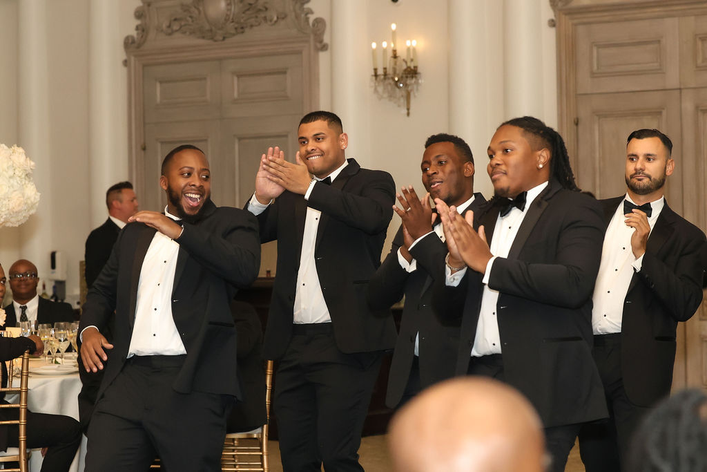 Groomsmen cheer during reception toasts in the Park Chateau ballroom, NJ luxury wedding