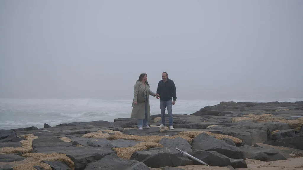 Walking hand in hand along the jetty as waves break against the rocks, New Jersey shore