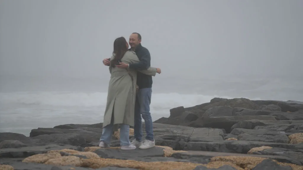 Smiles pressed together in an embrace on the rocks after the yes — New Jersey proposal session