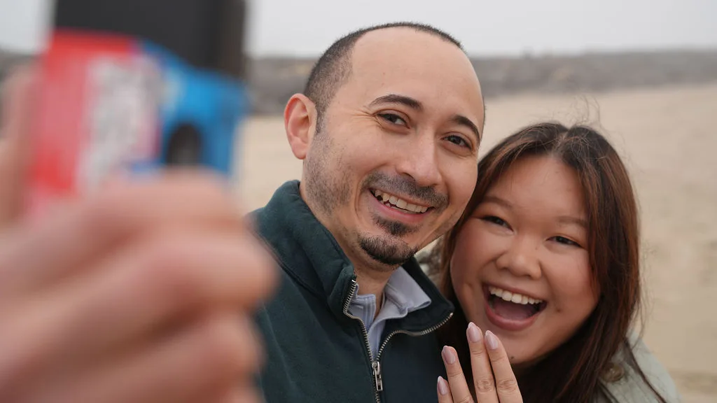 Through their own camera — the just-engaged couple grinning on the foggy beach, New Jersey